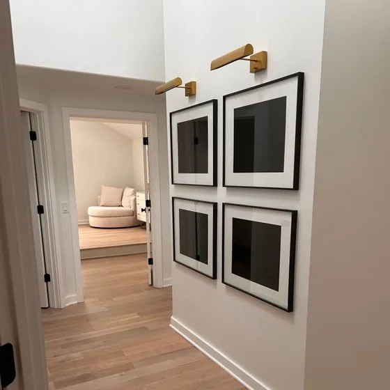 Hallway with framed prints and light oak floors