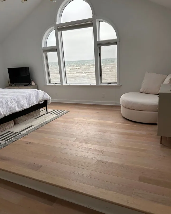 Bright bedroom with arched windows over the water