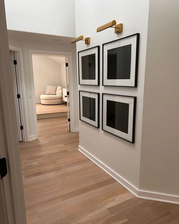 Hallway with framed art and oak floors
