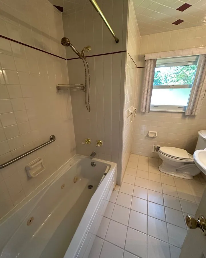 Bathroom with a jetted tub and tiled walls after cleaning