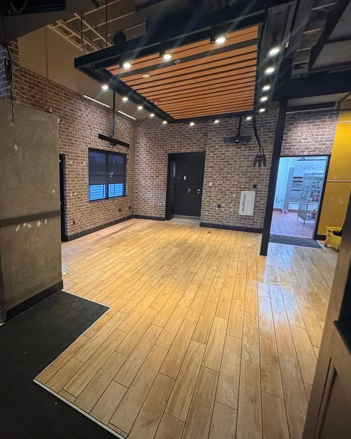 Loft-style commercial space with brick walls and wood floor
