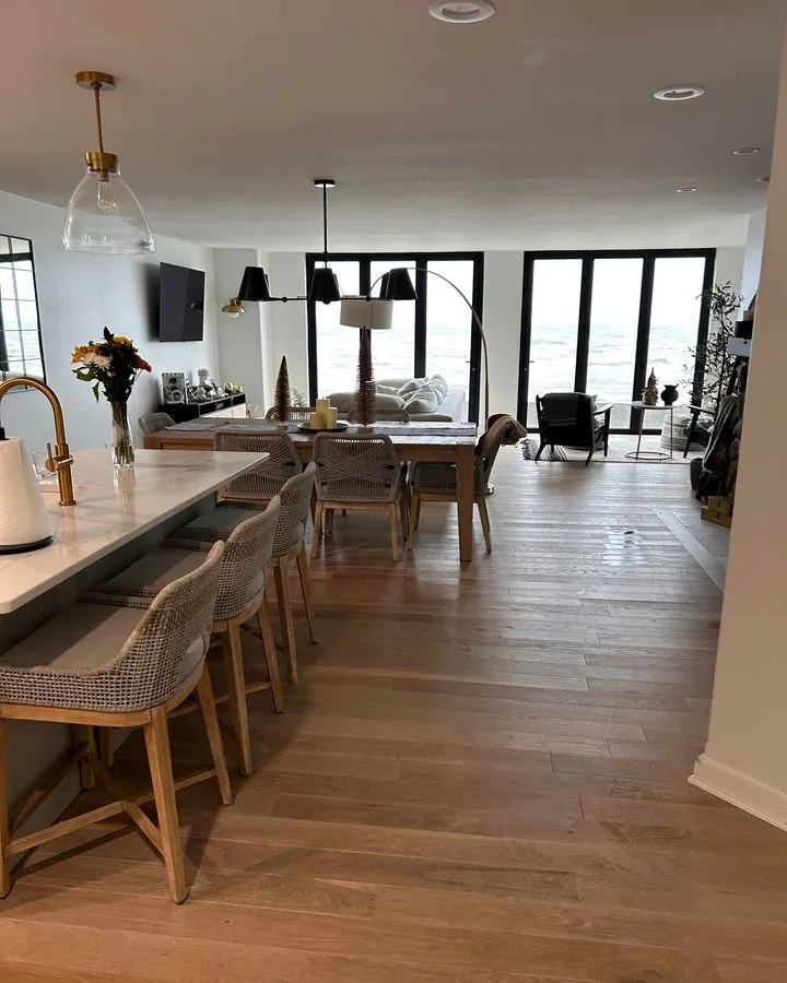Open kitchen and dining area with an island and wood floors after cleaning